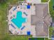 Aerial view of a community pool with plenty of seating, a spa, and an adjacent community building at 2611 Eagle Crest Ct, Holiday, FL 34691