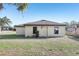 The backyard shows a home with a neutral exterior and a green lawn at 26377 Bertram Rd, Brooksville, FL 34602