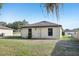 The backyard shows a home with a neutral exterior and a green lawn at 26377 Bertram Rd, Brooksville, FL 34602