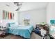 Bedroom with window, blue bedding, ceiling fan, and decorations at 26377 Bertram Rd, Brooksville, FL 34602