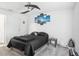 Bedroom featuring dark bedding, a ceiling fan, and a small side table at 26377 Bertram Rd, Brooksville, FL 34602
