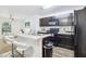 An open kitchen features dark cabinetry, an island with seating, and black appliances at 26377 Bertram Rd, Brooksville, FL 34602