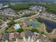 Aerial view of a neighborhood with a pool, playground, tennis and basketball courts, and a small pond at 27231 Liriope Ct, Wesley Chapel, FL 33544