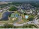 This is an aerial view of a neighborhood with pool, tennis court, basketball court, lake and playground amenities at 27231 Liriope Ct, Wesley Chapel, FL 33544