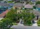 Birds-eye view of a home with mature trees in the front yard, surrounded by neatly landscaped lawns at 27231 Liriope Ct, Wesley Chapel, FL 33544