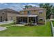 A spacious backyard with a screened in patio, lush green lawn, brick walkways and a white picket fence at 27231 Liriope Ct, Wesley Chapel, FL 33544