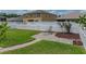 Backyard view featuring a white picket fence, brick patio with seating, and lush green lawn at 27231 Liriope Ct, Wesley Chapel, FL 33544