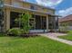 Spacious screened lanai overlooking the lush green backyard with landscaped garden beds and charming brick walkway at 27231 Liriope Ct, Wesley Chapel, FL 33544