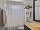 Cozy bathroom featuring a white shower curtain and vanity with neutral finishes and a floating shelf at 27231 Liriope Ct, Wesley Chapel, FL 33544