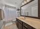 Well-lit bathroom featuring a vanity with a large mirror and a shower with neutral finishes at 27231 Liriope Ct, Wesley Chapel, FL 33544