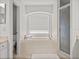 Bright bathroom featuring a large soaking tub under an arched window at 27231 Liriope Ct, Wesley Chapel, FL 33544