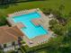 An aerial view of the community pool area that has a large T-shaped pool, tables and lounge chairs at 27231 Liriope Ct, Wesley Chapel, FL 33544