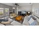 Well-lit living room with a large sofa, area rug, and access to outdoor patio at 27231 Liriope Ct, Wesley Chapel, FL 33544