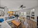 A spacious living room with a plush sofa, view into the kitchen, and access to the backyard at 27231 Liriope Ct, Wesley Chapel, FL 33544