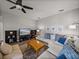 Comfortable living room with a large sectional sofa, ceiling fan, and stylish decor at 27231 Liriope Ct, Wesley Chapel, FL 33544