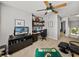 Another angle of the upstairs carpeted office space with ceiling fan and media center at 27231 Liriope Ct, Wesley Chapel, FL 33544