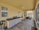 Spacious screened patio featuring outdoor kitchen, tile floors, and access to a cozy seating area at 27231 Liriope Ct, Wesley Chapel, FL 33544