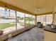 Comfortable screened-in patio with tile flooring, ceiling fan, and a view of the well-maintained backyard at 27231 Liriope Ct, Wesley Chapel, FL 33544