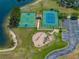 This is an aerial view of the basketball court, tennis court, and playground next to the lake at 27231 Liriope Ct, Wesley Chapel, FL 33544