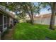 Well-maintained backyard with lush grass, mature trees, and privacy fencing for a serene outdoor experience at 3073 Overlook Pl, Clearwater, FL 33760
