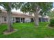 Expansive backyard with mature trees and a view of multiple screened porches for outdoor enjoyment at 3073 Overlook Pl, Clearwater, FL 33760