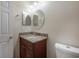 Bathroom features a vanity with granite countertop, a round mirror and tile flooring at 3073 Overlook Pl, Clearwater, FL 33760