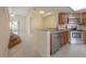Open kitchen featuring stainless steel appliances and granite countertops with nearby living area at 3073 Overlook Pl, Clearwater, FL 33760