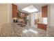 This kitchen features an island with granite countertops and stainless steel double sink at 3073 Overlook Pl, Clearwater, FL 33760