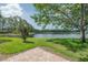 Scenic lake view with lush greenery and a paver patio in a serene community setting at 3073 Overlook Pl, Clearwater, FL 33760