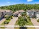 Aerial view of a home with beautiful landscaping features a brick paved driveway and a neatly manicured lawn at 31050 Spruceberry Ct, Wesley Chapel, FL 33543