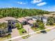 Aerial view of a community with mature trees shows attractive houses with brick-paved driveways and meticulously landscaped yards at 31050 Spruceberry Ct, Wesley Chapel, FL 33543