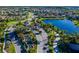 Aerial view of community with lake, lush landscaping, community entrance, and well-maintained homes at 31050 Spruceberry Ct, Wesley Chapel, FL 33543