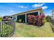 The backyard boasts a screened-in lanai, complemented by lush landscaping and a black fence, ensuring privacy at 31050 Spruceberry Ct, Wesley Chapel, FL 33543