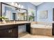 Bright bathroom featuring dual vanity, granite countertop, soaking tub, and tiled shower at 31050 Spruceberry Ct, Wesley Chapel, FL 33543