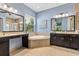 Light and airy bathroom featuring a soaking tub, dual vanity and light blue walls at 31050 Spruceberry Ct, Wesley Chapel, FL 33543