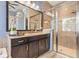 Bright bathroom featuring dual vanity, granite countertop, tiled shower with glass door, and tiled surround at 31050 Spruceberry Ct, Wesley Chapel, FL 33543