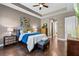 Comfortable bedroom featuring a tray ceiling, rich wood floors, and a view into the bath and closet at 31050 Spruceberry Ct, Wesley Chapel, FL 33543