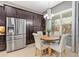 Cozy dining area with modern chandelier, large window, and a view into the kitchen at 31050 Spruceberry Ct, Wesley Chapel, FL 33543