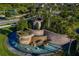 Aerial view of the community entrance featuring water features, landscaping, and stone architecture at 31050 Spruceberry Ct, Wesley Chapel, FL 33543