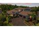 Stunning exterior view shows a home with a brick-paved driveway, lush landscaping, and a three-car garage at 31050 Spruceberry Ct, Wesley Chapel, FL 33543