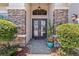 Elegant front door with decorative wreaths, stone accents, and manicured landscaping at 31050 Spruceberry Ct, Wesley Chapel, FL 33543