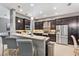 Well-equipped kitchen with dark wood cabinets, stainless steel appliances, and bar seating at 31050 Spruceberry Ct, Wesley Chapel, FL 33543