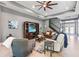 Comfortable living room with a tray ceiling, ceiling fan, and open access to the foyer at 31050 Spruceberry Ct, Wesley Chapel, FL 33543