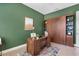 This office features wooden accents, green walls, a desk, and a day bed behind doors at 31050 Spruceberry Ct, Wesley Chapel, FL 33543