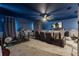 Home theater room featuring a wall-mounted screen, reclining chairs, and fitness equipment at 31050 Spruceberry Ct, Wesley Chapel, FL 33543