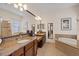 Bright bathroom featuring granite countertops, dual sinks, a tub, and natural lighting at 3142 Stonegate Falls Dr, Land O Lakes, FL 34638
