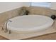Modern soaking tub with tiled surround in bathroom with beautiful faucet hardware at 3142 Stonegate Falls Dr, Land O Lakes, FL 34638