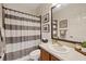 Bright bathroom featuring wood vanity, modern fixtures, and a stylish gray-and-white striped shower curtain at 3142 Stonegate Falls Dr, Land O Lakes, FL 34638