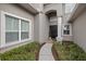 Inviting front entrance with a pathway, manicured bushes, and a column-supported porch at 3142 Stonegate Falls Dr, Land O Lakes, FL 34638