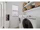 Bright laundry room with modern washer and dryer, shelving, and natural light at 3142 Stonegate Falls Dr, Land O Lakes, FL 34638